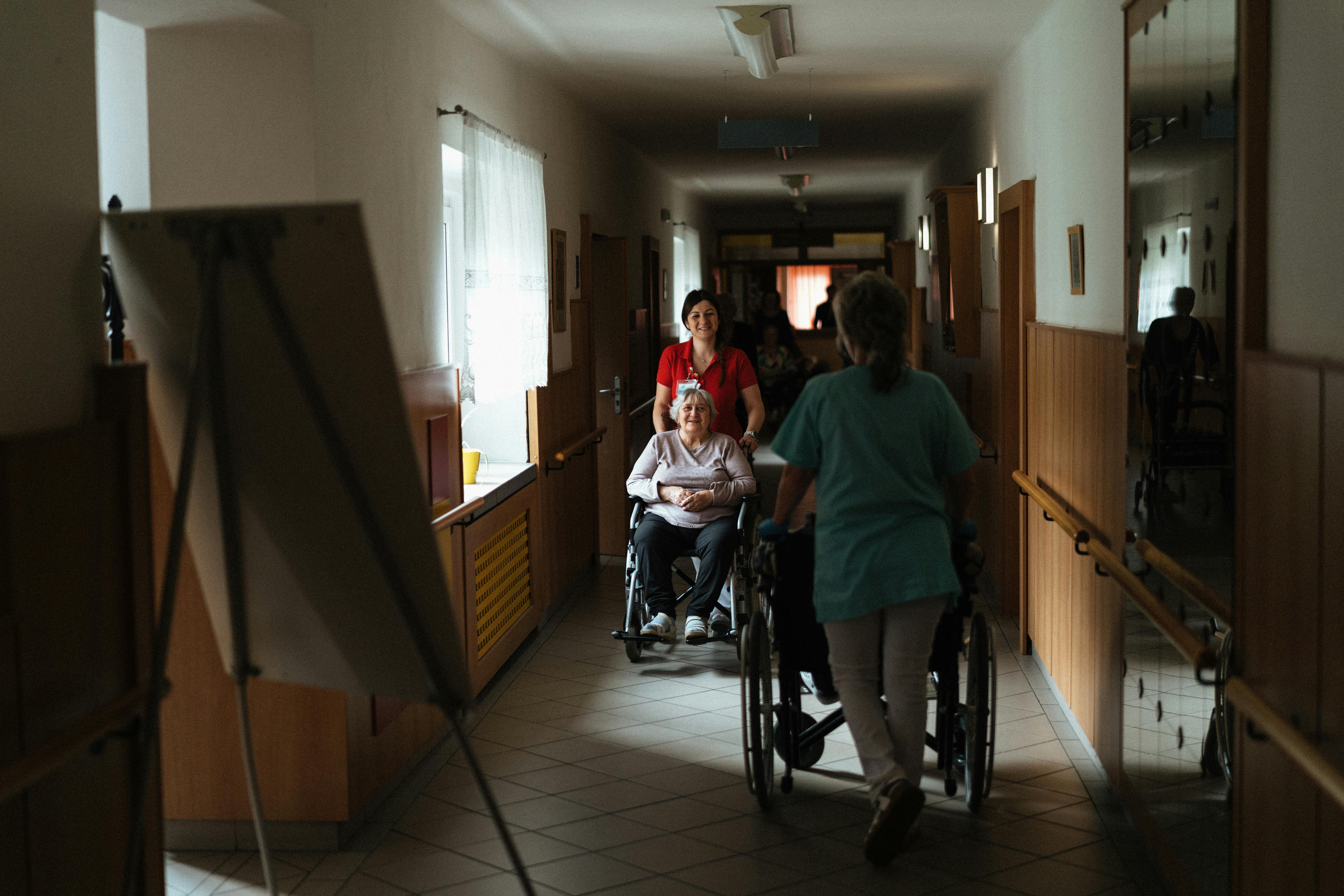 Resident being supported through a care facility hallway